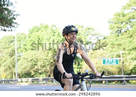 NEW YORK CITY - JULY 19 2015: thousands endured heat & humidity to complete the final 10 kilometer leg of the NYC Panasonic Triathlon in Central Park. Bike portion of Triathlon on Henry Hudson Prkwy