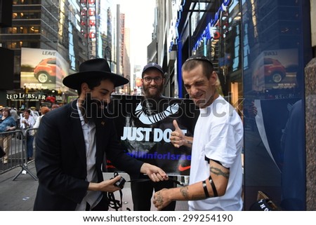 NEW YORK CITY - JULY 22 2015: thousands rallied in Times Square to oppose the President\'s proposed nuclear deal with Iran. Chabad Lubavitch members help men apply tefilin