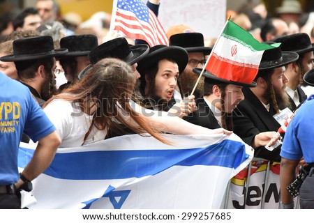 NEW YORK CITY - JULY 22 2015: thousands rallied in Times Square to oppose the President's proposed nuclear deal with Iran. Rally members fight over flags with anti-zionist Neturei Karta members