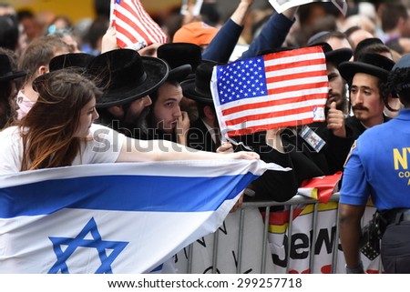 NEW YORK CITY - JULY 22 2015: thousands rallied in Times Square to oppose the President\'s proposed nuclear deal with Iran. Woman blocks anti-zionist Neturei Karta members with Israeli flag