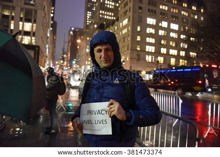 NEW YORK CITY - FEBRUARY 23 2016: privacy activists braved cold rain to stand in front of the Apple 5th Ave store to encourage refusal to cooperate with the FBI in cracking the iPhone\'s encryption.