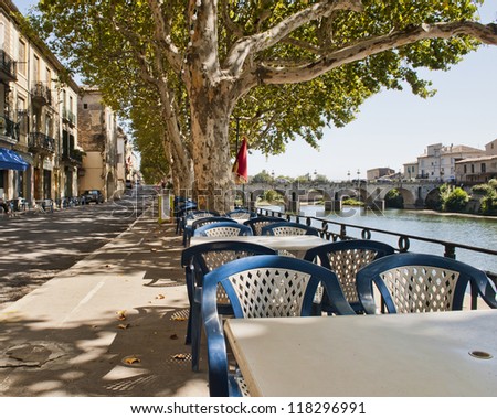 Dining tables by the river in Sommieres France