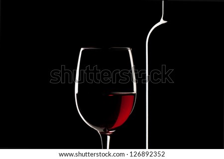 Elegant Red Wine Glass And A Wine Bottle In Black Background