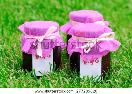 Plum and peach jam in glass jar on white background