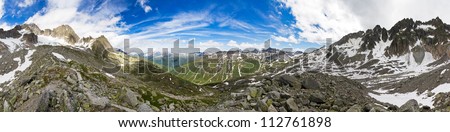 360 degree panorama taken in the mountains on top of the Furkapass in the Swiss Alps on a sunny day with a beautiful cloudscape