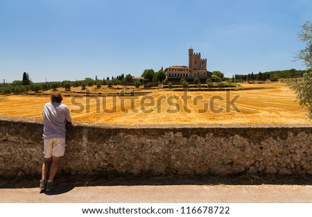 Man looking at an old country house in Tuscany, Italy