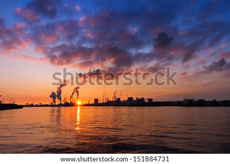 Sunset view of the heavy industry with smoking chimneys in IJmuiden, the Netherlands
