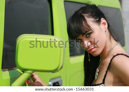 The girl in bikini poses at the car