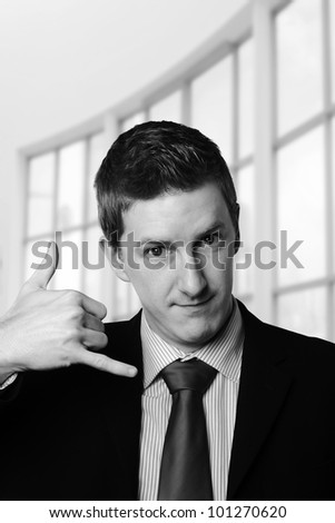 businessman making the sign for give me a call with his hand