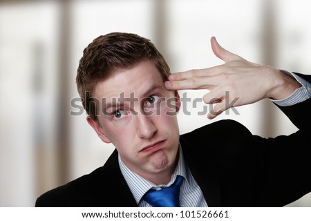 business man point his fingers to his head as if he about to shoot himself