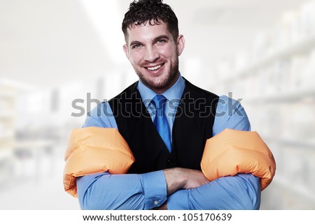 handsome business type man wearing rubber arm bands looking at the camera looking silly
