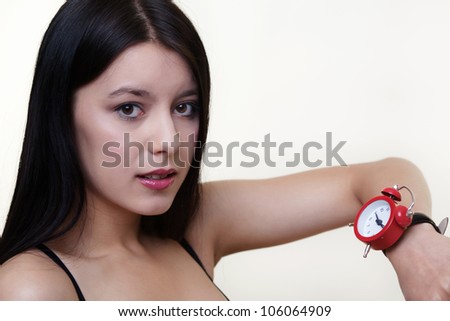 young woman with a large wrist watch looking at the time looks like shes not on time