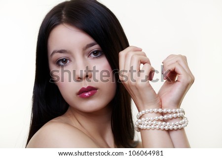 young woman with a pearl necklace wrapped around both wrists as if she was tie up