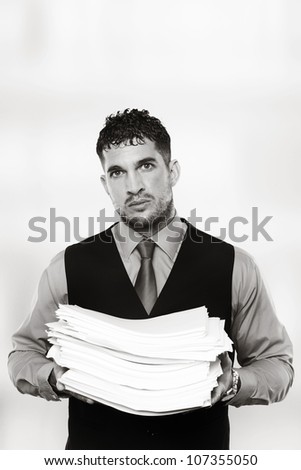 man holding a large pile of paper work in his arms has lot of work to do