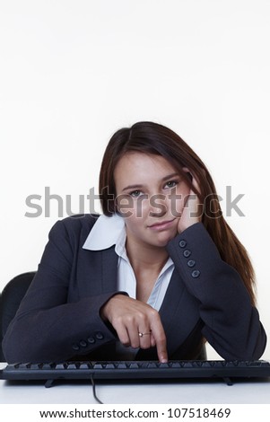 very young looking woman looking bored and not happy at work cant wait to go home