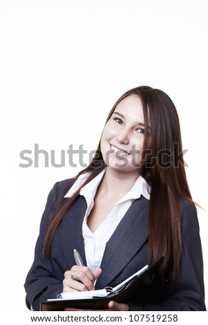 very young looking woman in a suit just starting out trying to do well in business taking notes in her filo fax