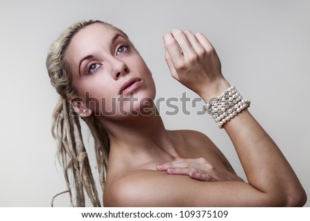 sexy woman with dreadlocks hair with pearls around her wrist