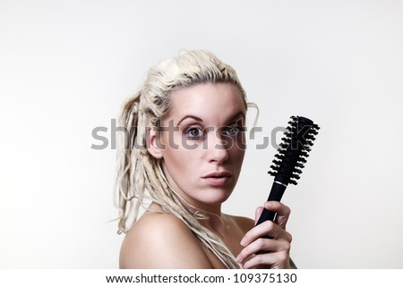 sexy woman with dreadlocks hair holding a hair brush with not much need for it