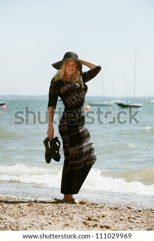 sexy woman standing in the water edge posing for the camera on a hot sunny day