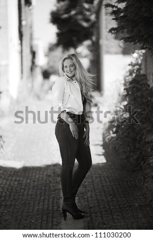 woman walking down a alleyway looking round back at the camera