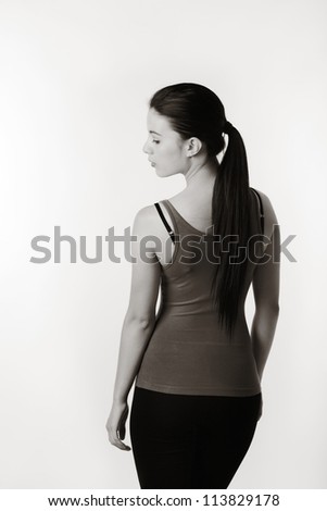 woman standing in exercise clothes with her back to camera and side side profile face