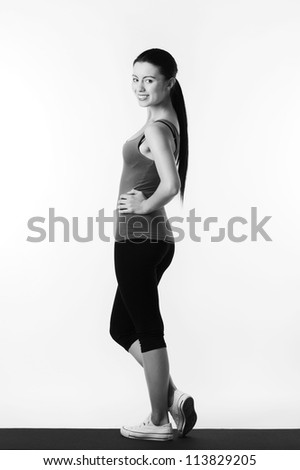 woman standing on a exercise mat looking very happy after a work out