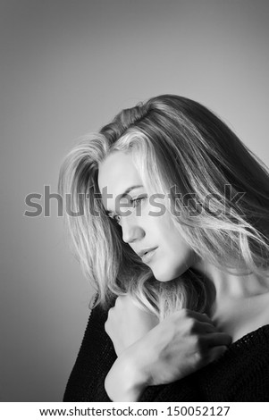 single head shot of woman posing wearing a knitwear top off the shoulder
