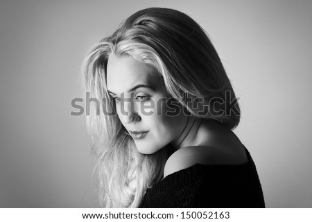 single head shot of woman posing wearing a knitwear top off the shoulder