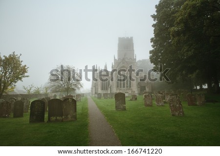View of English church and church yard on a misty morning