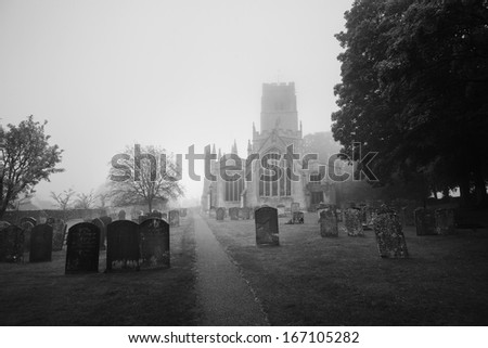 View of English church and church yard on a misty morning