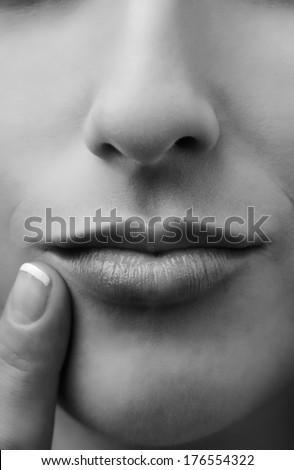 female sensual lips closeup with finger by her lips