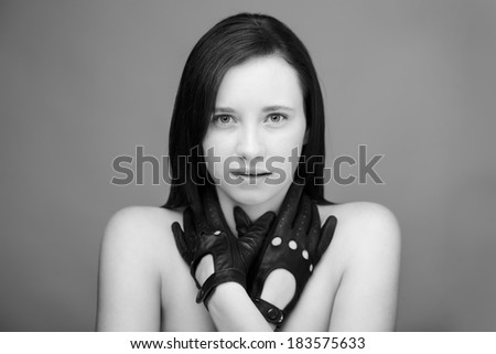 head shot of a young woman shot in the studio looking into camera model is wearing leather driving gloves