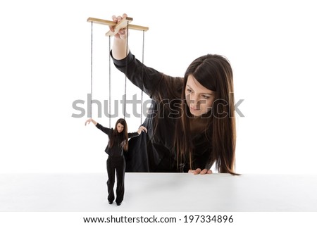 business woman holding a puppet of herself pulling strings