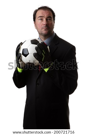 Business man holding a traditional black and white football wearing goalie gloves