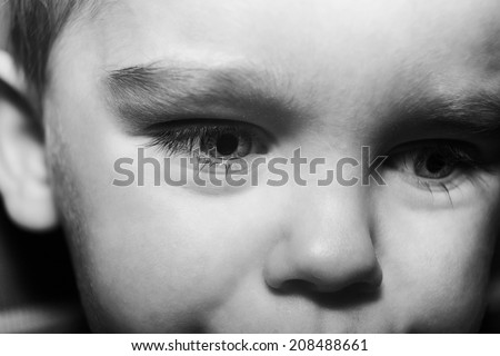 close up shot of a young boys face not looking happy as if hes about to cry