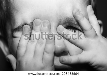 close up shot of a young boys face not looking happy as if hes about to cry