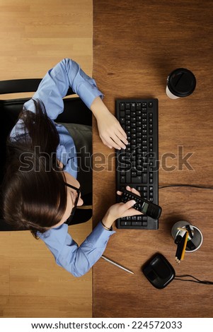 woman at her desk on the phone working taken from a birds eye view