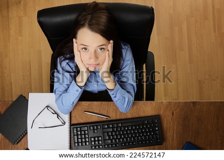woman at her desk feeling the stress of work, taken from a birds eye view