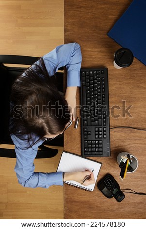 woman typing and working hard at her desk taken from a birds eye view