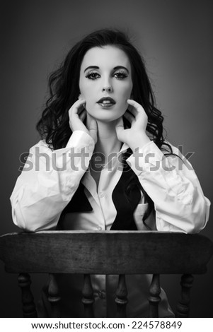 beauty portrait of young woman shot in the studio sitting on an old wooden chair