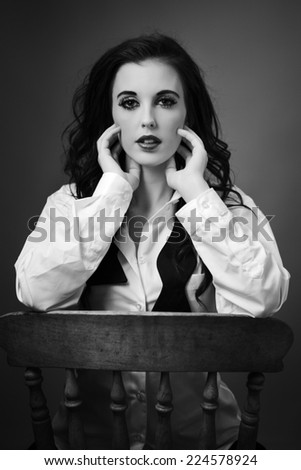 beauty portrait of young woman shot in the studio sitting on an old wooden chair