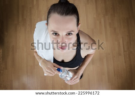 fitness woman drinking water after a workout, view point is high above the model