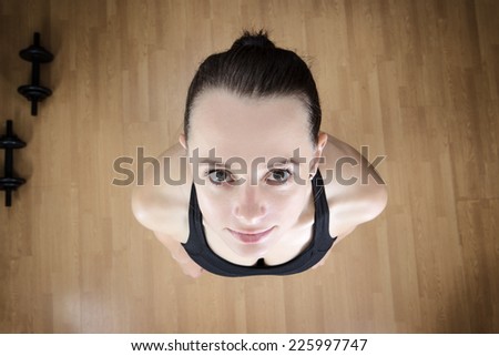 fitness woman looking up at camera at a high view point above the model