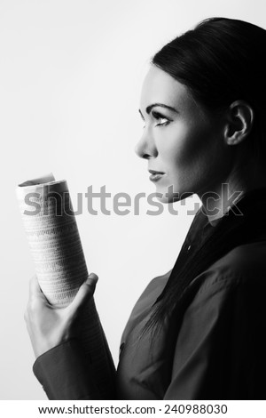 woman holding a financial paper showing stock and shares