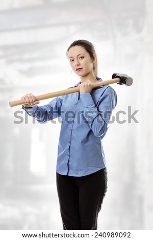 business woman holding a large sledgehammer get ready for trouble