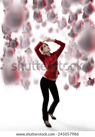 standing woman with arms up above her head protecting  her self from falling clocks