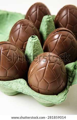 small chocolate eggs sitting in a cardboard egg box