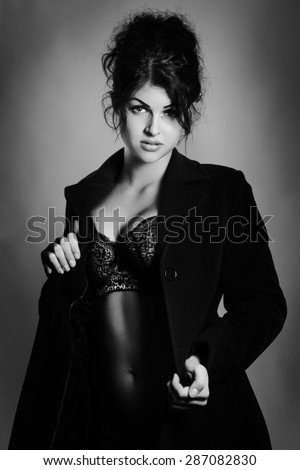 shot of a sexy woman in underwear wearing a large coat  shot in the studio