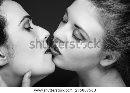 two women kissing each other in love shot in black and white