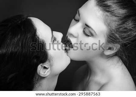 two women kissing each other in love shot in black and white